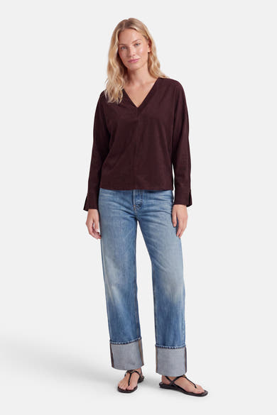 Blouse violette à manches longues et col en V par AMELIE ET AMELIE, vue de face sur modèle portant jeans délavés et sandales noires