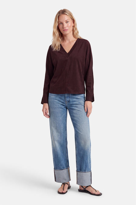 Blouse violette à manches longues et col en V par AMELIE ET AMELIE, vue de face sur modèle portant jeans délavés et sandales noires