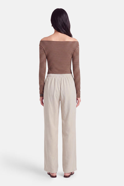 Pantalon écru à taille élastique par AMELIE ET AMELIE, vue arrière, coupe large et fluide, porté avec top rayé et sandales marron