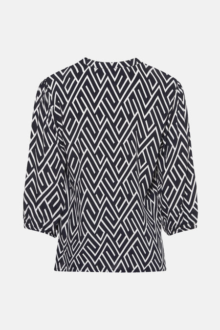 Donkerblauwe blouse ZABAIONE met wit geometrisch patroon over het hele kledingstuk, driekwart pofmouwen.
