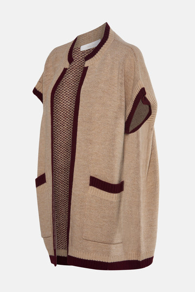 Gilet beige en maille d'AMELIE ET AMELIE, avec bordures bordeaux, poches plaquées et texture ajourée intérieure.
