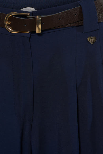 Navy blue suit trousers by Ame & Amour with textured fabric, brown leather belt, gold buckle, and heart-shaped pin detail, front close-up view