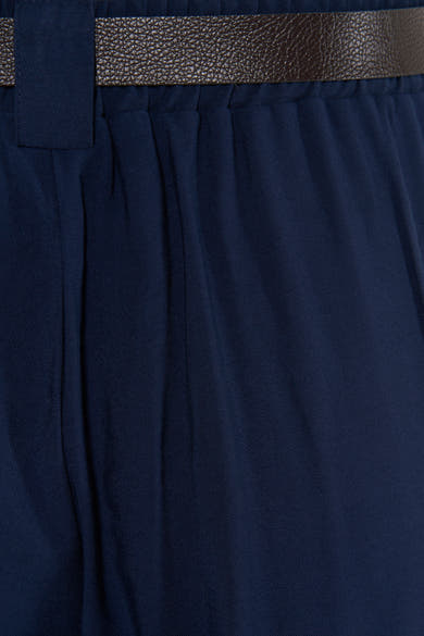 Navy blue suit trousers with front pleats and textured brown belt, close-up view