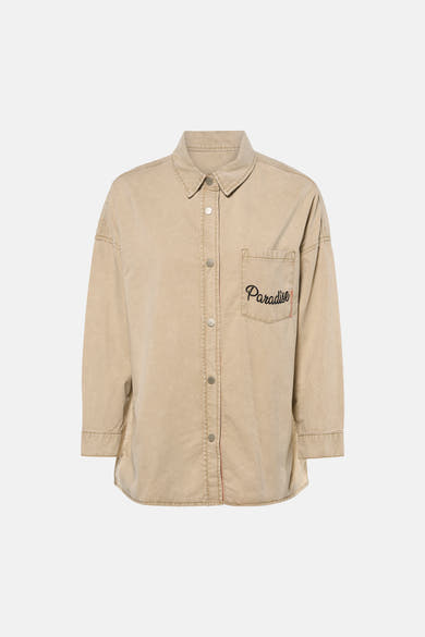 Chemise beige à manches longues de ADORE, avec poche poitrine ornée du mot « Paradise ».
