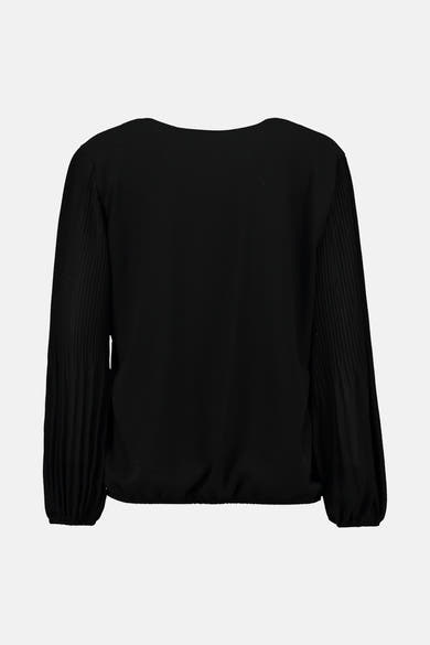 Blouse noire à manches longues de Zabaione, avec des manches plissées et une taille élastique.