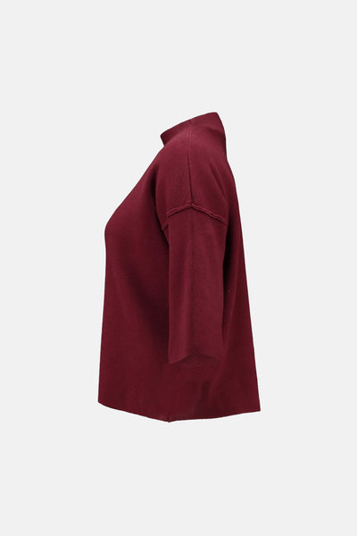 Pull à col roulé rouge de Zabaione, coupe ample avec manches trois-quarts en vue latérale.
