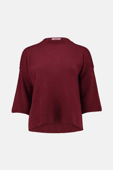 Pull à col roulé rouge de Zabaione, manches trois-quarts évasées et ourlet arrondi.