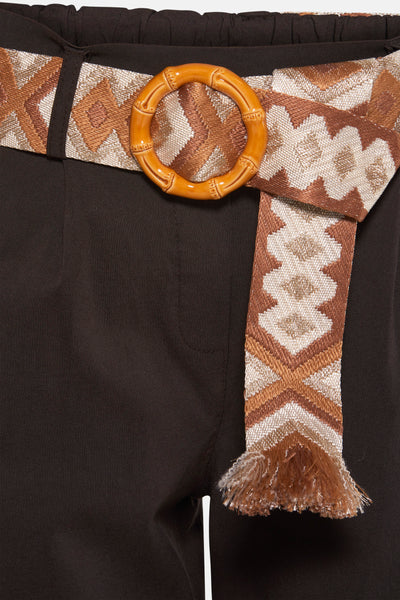 Chino brun de ZABAIONE avec ceinture ethnique à boucle ronde façon bambou et détails de franges.
