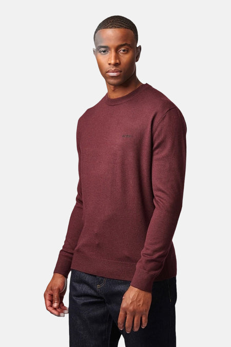 Bordeaux crewneck sweater by A.P.C. with ribbed cuffs and hem, worn with dark jeans, front view