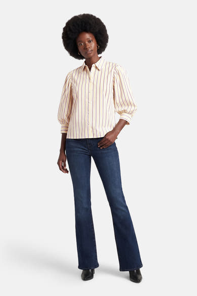 Multikleurig overhemd met korte mouwen van AMELIE ET AMELIE, met gele en paarse verticale strepen, gedragen met een donkerblauwe jeans.
