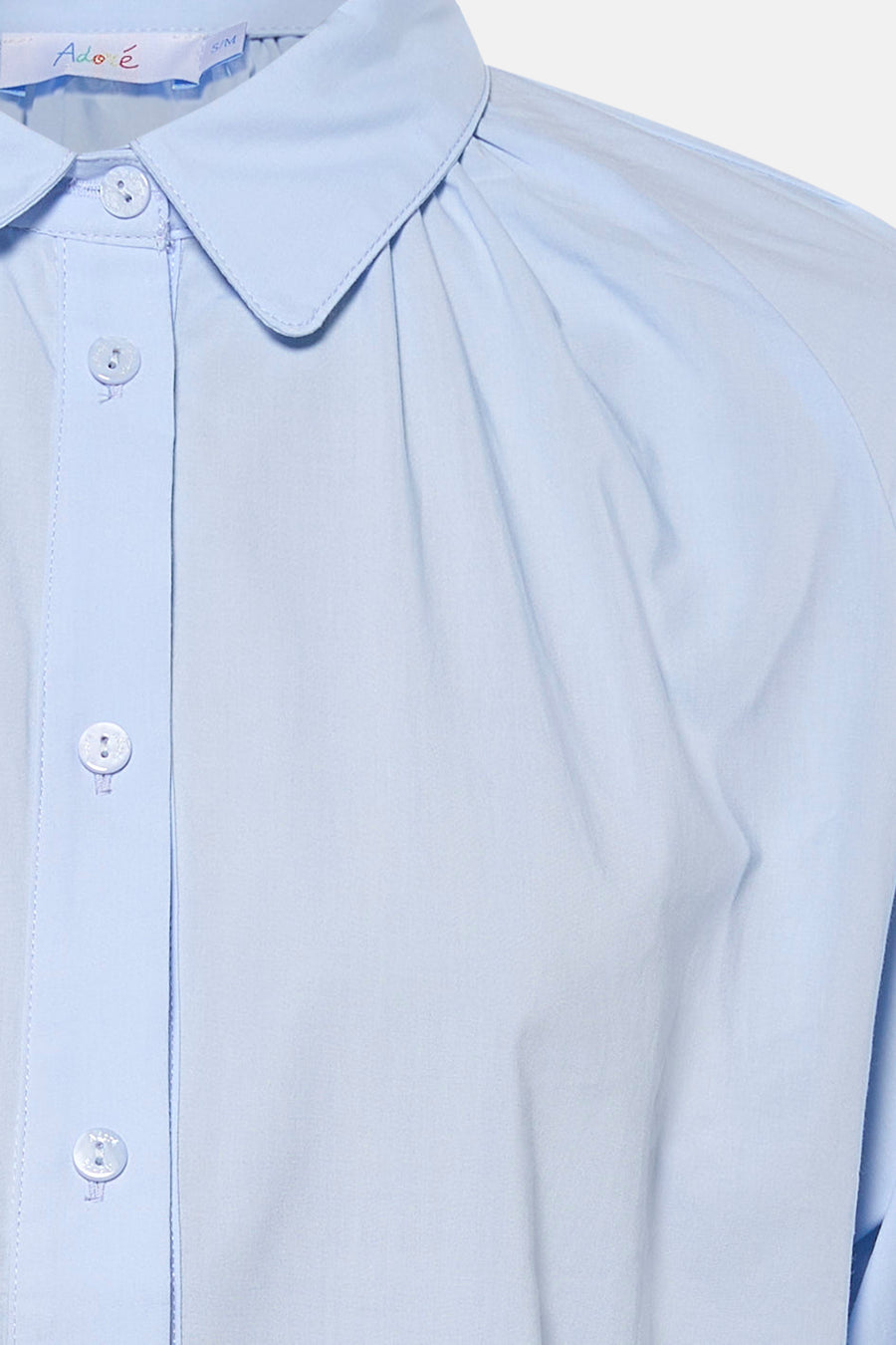 Chemise bleue à manches longues de ADORE, avec col arrondi et patte de boutonnage.