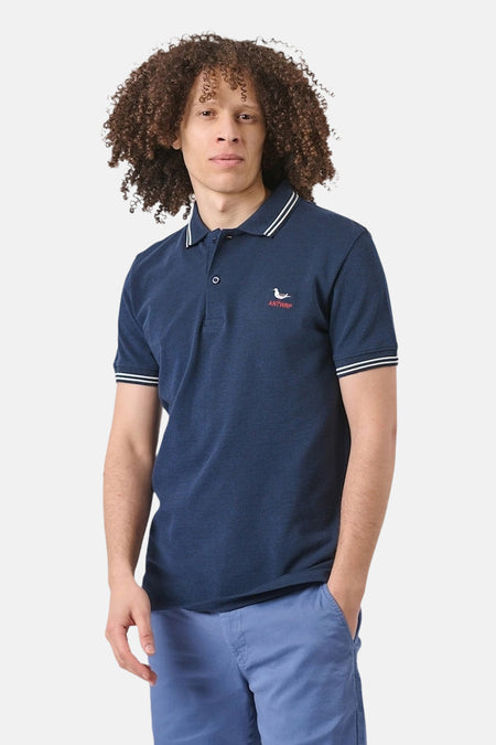 Marineblauw poloshirt met korte mouwen van ANTWRP, met witte strepen op de kraag en mouwen, gedragen met een blauwe korte broek.