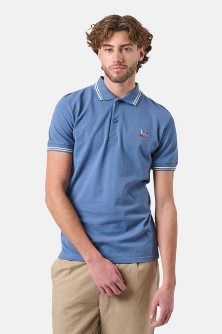 Blauw poloshirt met korte mouwen van ANTWRP, met witte bies op de kraag en mouwen, gedragen met een beige broek.