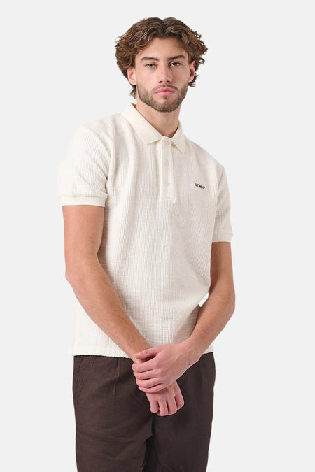 Wit poloshirt met korte mouwen van ANTWRP, in wafeltextuur, gedragen met een bruine broek.