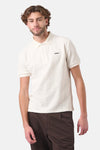 Wit poloshirt met korte mouwen van ANTWRP, textuurstof, gedragen met een bruine broek.
