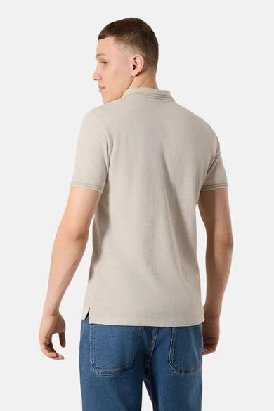 Polo beige par ANTWRP, vue de dos, porté avec un jean bleu.