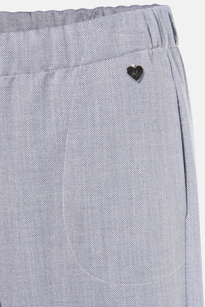 Pantalon bleu chiné par AMELIE ET AMELIE, avec un détail décoratif en forme de cœur métallique.