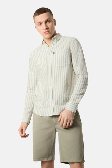 Chemise à rayures vertes et blanches par ANTWRP, avec poche poitrine, portée avec un short kaki.