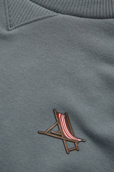 Sweat bleu d'ANTWRP, avec un petit motif de chaise de plage rayée.