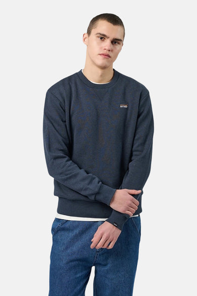 Gemêleerd blauw sweatshirt met ronde hals van ANTWRP, gedragen over een wit T-shirt en een blauwe jeans.