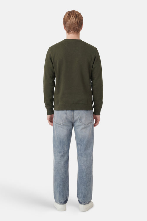 Kaki ANTWRP sweatshirt, klassieke pasvorm, gedragen met een lichtblauwe jeans en witte sneakers, achtergezicht.