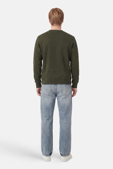 Kaki ANTWRP sweatshirt, klassieke pasvorm, gedragen met een lichtblauwe jeans en witte sneakers, achtergezicht.