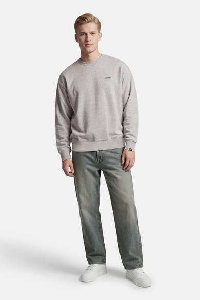 Sweat-shirt gris col rond par ANTWRP, porté avec un jean délavé et des baskets blanches.