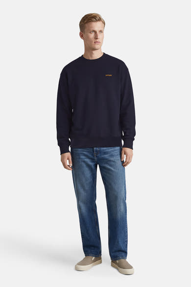 Sweat-shirt bleu marine d'ANTWRP, porté avec un jean bleu et des espadrilles grises.