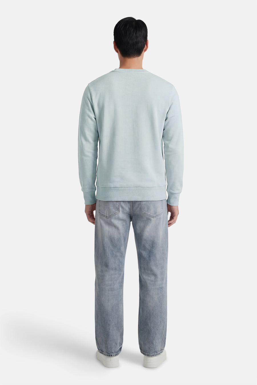 Sweat-shirt bleu col rond de ANTWRP, porté avec un jean délavé et des chaussures de sport blanches, vue de dos.

