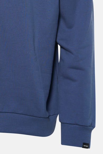 Sweat bleu van ANTWRP, avec des bordures côtelées aux poignets et à l'ourlet, sur un fond blanc.