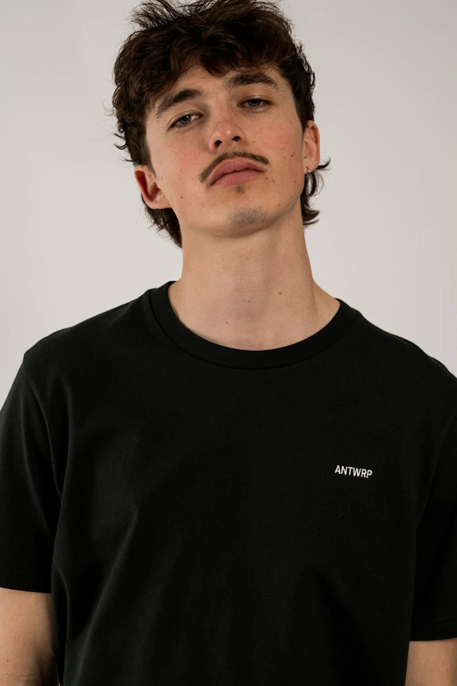 T-shirt noir à manches courtes de ANTWRP, avec un logo blanc discret sur la poitrine.
