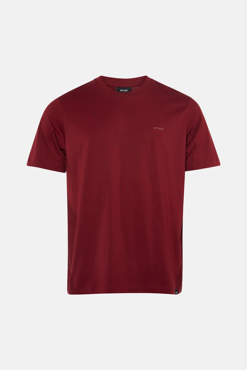 Roze T-shirt met korte mouwen van ANTWRP, gedragen met een verbleekte spijkerbroek en witte sneakers.