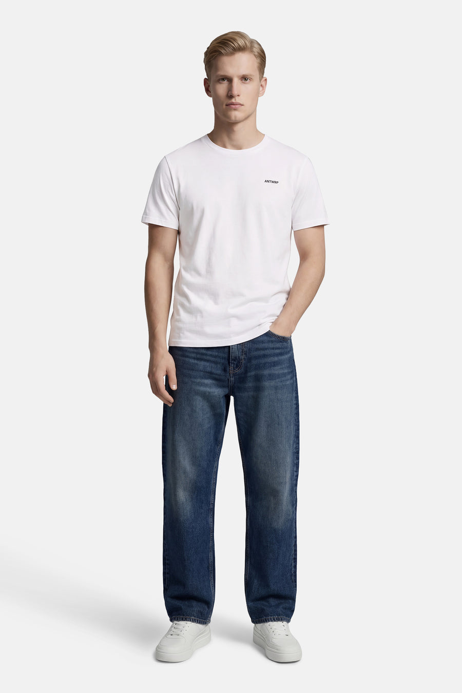 T-shirt blanc à manches courtes d'ANTWRP, porté avec un jean bleu et des baskets blanches.