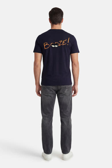 Marineblauwe T-shirt met korte mouwen van ANTWRP met oranje humoristische opdruk op de rug, gedragen met een grijze jeans.