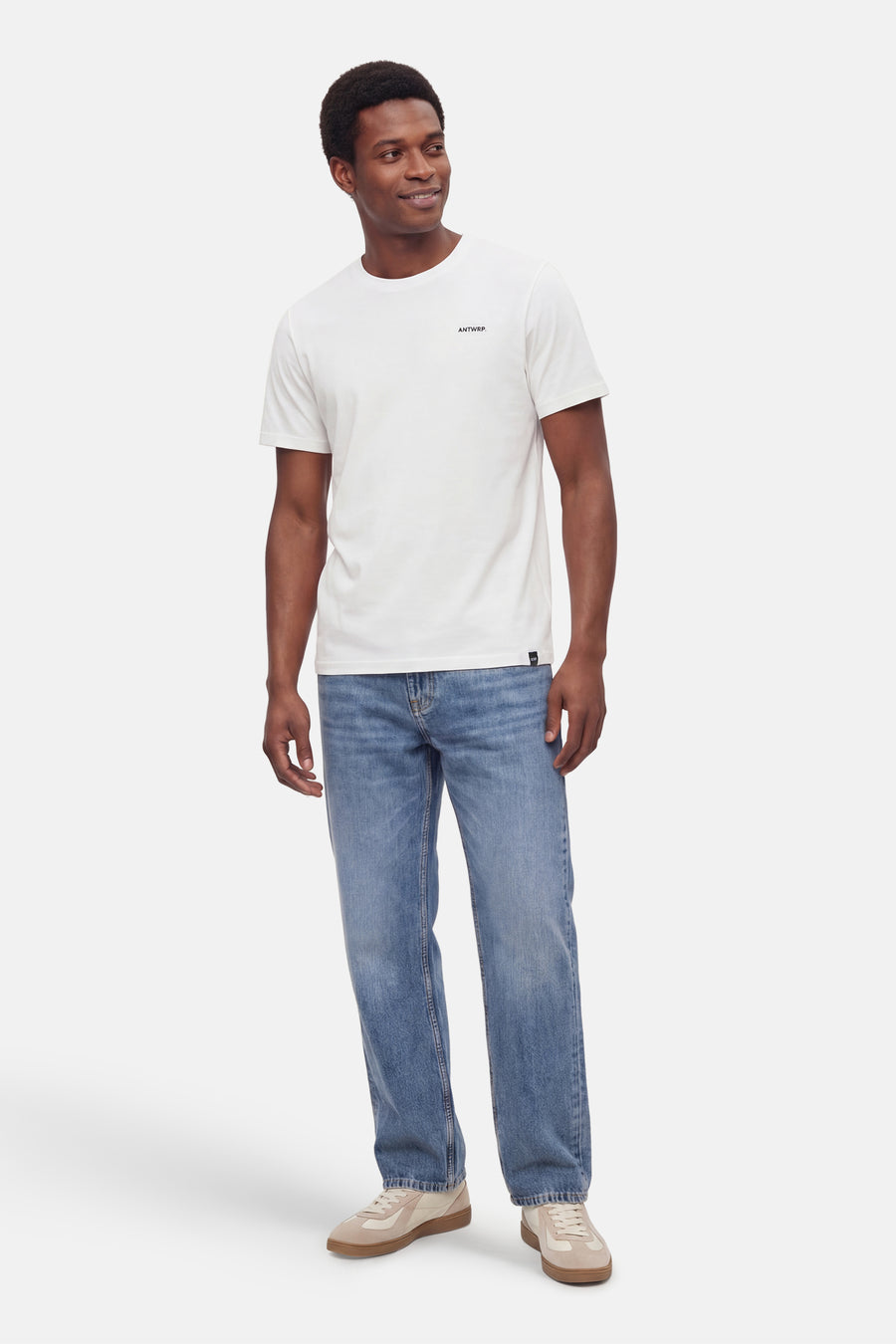 Wit T-shirt met korte mouwen van ANTWRP, gedragen met een casual spijkerbroek en neutrale suède sneakers.