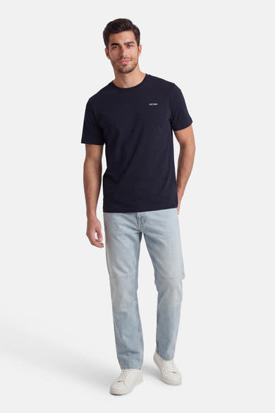 T-shirt à manches courtes bleu de ANTWRP, porté avec un jean décontracté et des baskets blanches.
