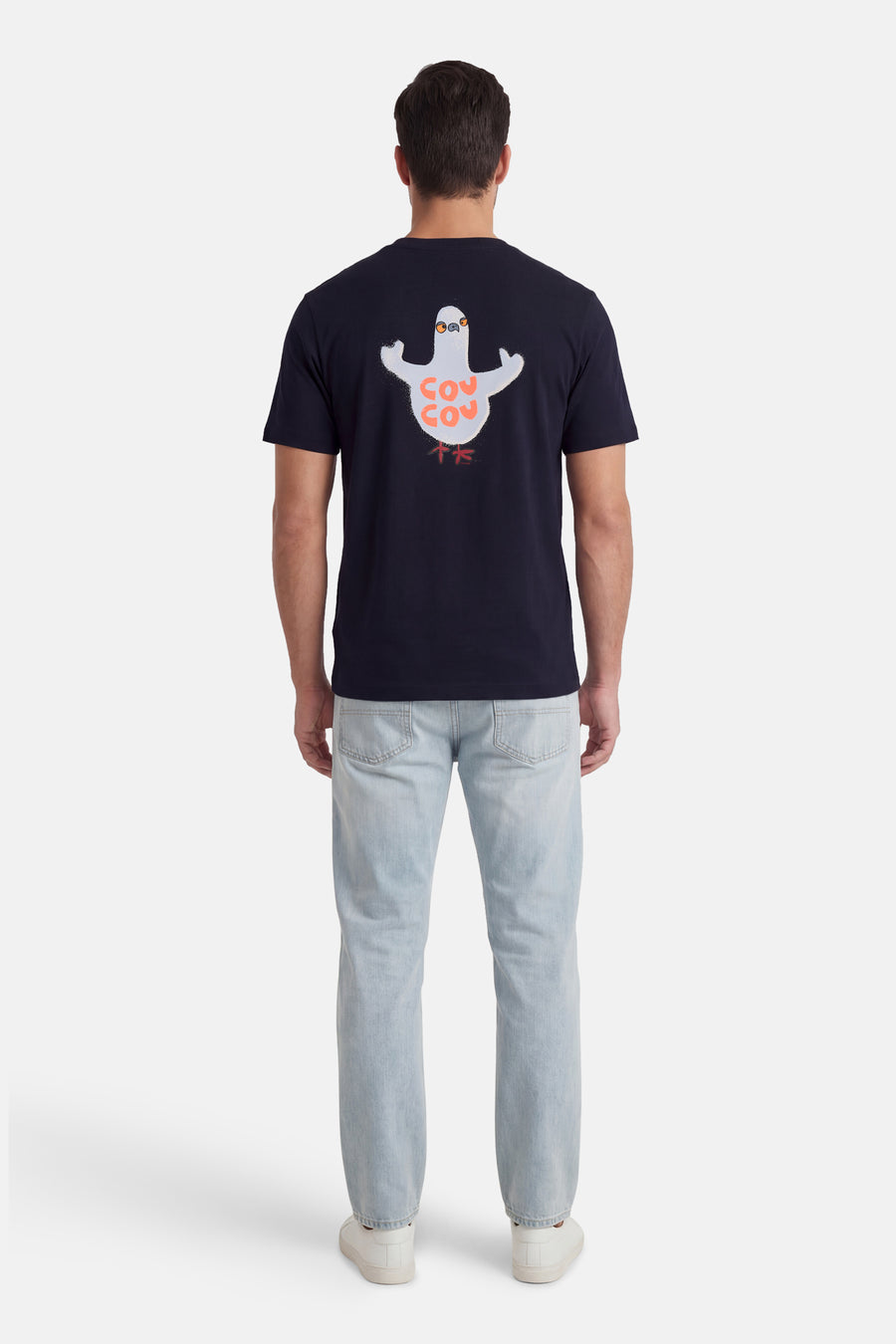 T-shirt à manches courtes bleu de ANTWRP, avec un imprimé de pigeon et porté avec un jean clair et des chaussures blanches.