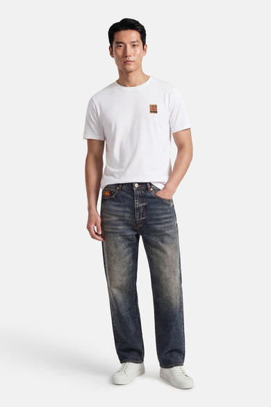T-shirt à manches courtes blanc de ANTWRP, porté avec un jean délavé et des baskets blanches.