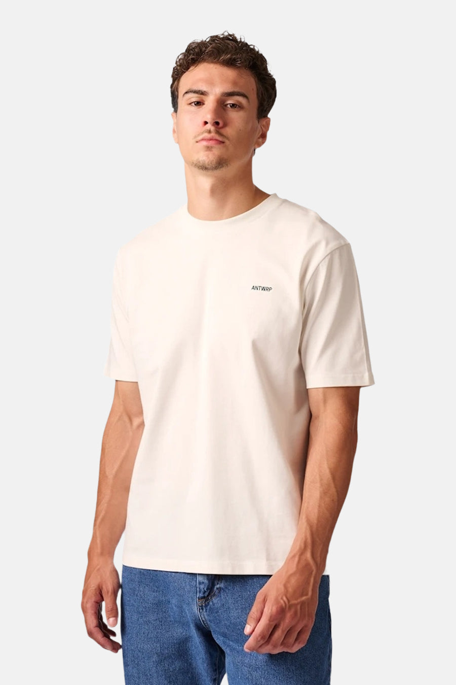 Ecru short-sleeve t-shirt by ANTWRP, featuring small chest logo, worn with blue jeans, front view