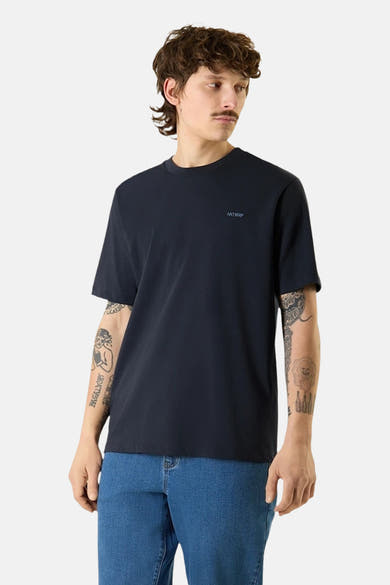 T-shirt bleu à manches courtes de ANTWRP, porté avec un jean bleu, sur fond uni.
