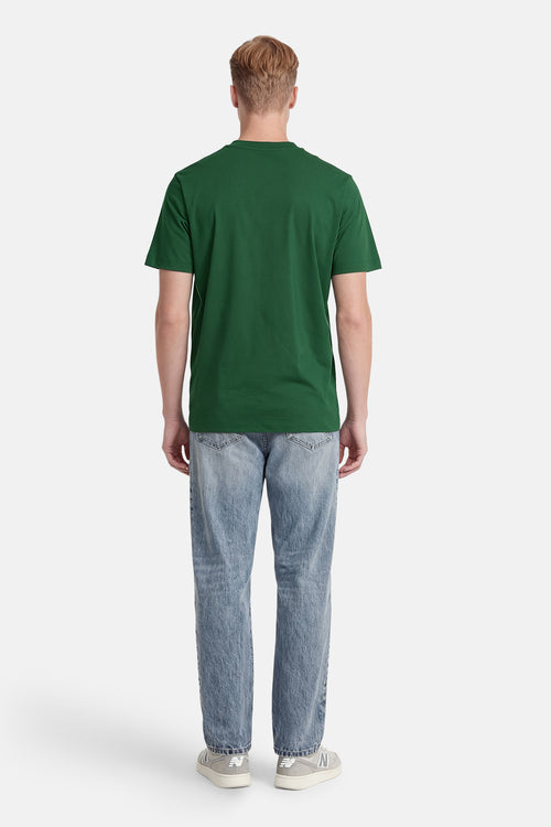 T-shirt à manches courtes vert de ANTWRP, porté avec un jean bleu clair et des baskets grises, vue de dos.