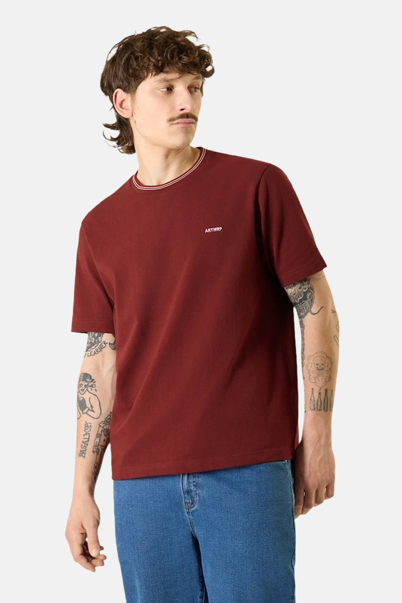 T-shirt bordeaux à manches courtes d'ANTWRP, avec col rayé et porté avec un jean bleu.