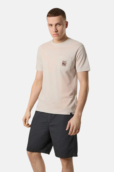 T-shirt beige à manches courtes de ANTWRP, avec poche poitrine à motif décoratif, porté avec un short noir.