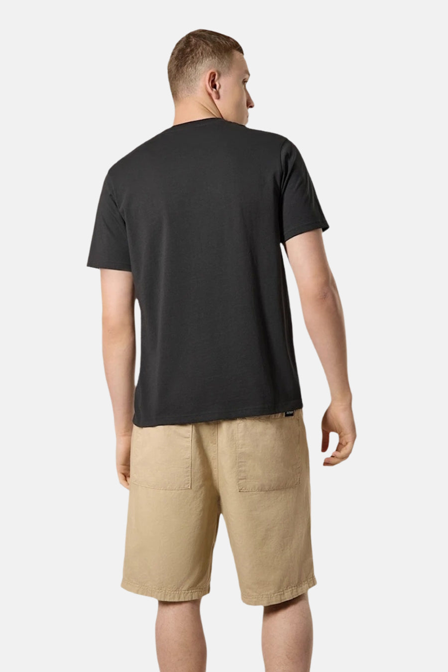 T-shirt noir de ANTWRP, vue de dos, porté avec un short beige en toile.