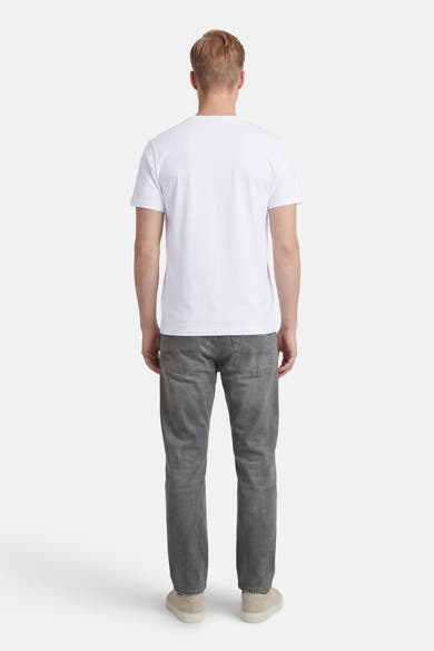 T-shirt à manches courtes blanc de ANTWRP, vue de dos, porté avec un jean gris et des chaussures couleur crème.

