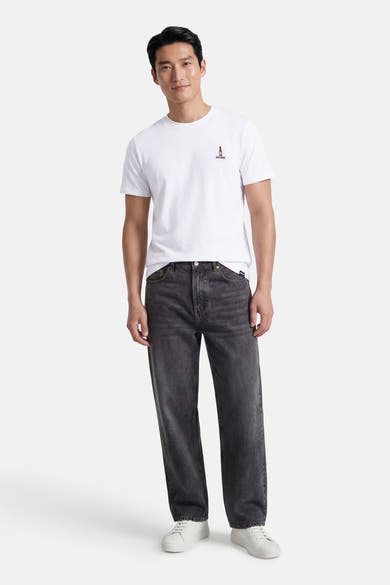 T-shirt blanc à manches courtes de ANTWRP, porté avec un jean noir délavé et des baskets blanches.