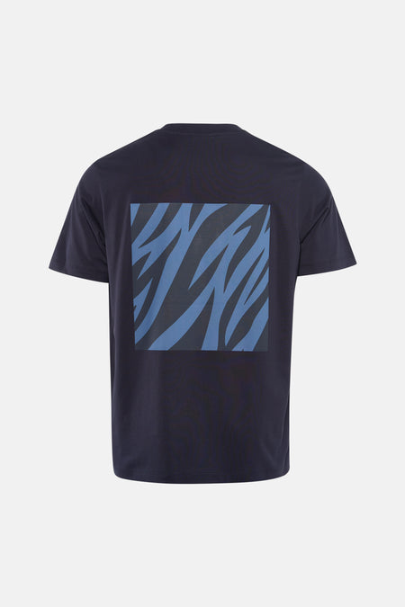 Blauw T-shirt met korte mouwen van ANTWRP, met een abstract grafisch patroon op de rug, gedragen met een lichte spijkerbroek en beige schoenen.