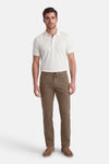 Pantalon coloré kaki de PIERRE CARDIN, porté avec un polo blanc et des mocassins marron.