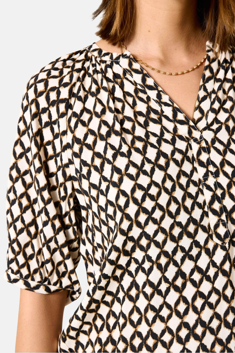 Multikleurige blouse van GARCIA, met een zwart en beige ruitpatroon, een V-hals en een gouden ketting.