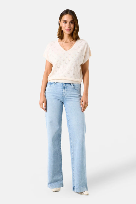 Ecru V-hals trui van GARCIA, versierd met delicate openwerkpatronen, gedragen met een wijde jeans en een gouden ketting.